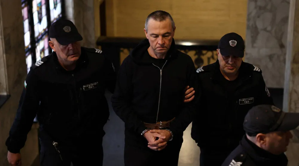 عنصران من الشرطة البلغارية يقودان الروسي إيغور غريتشوشكين إلى قاعة المحكمة في بلغاريا للاستماع إلى إفادته (رويترز)