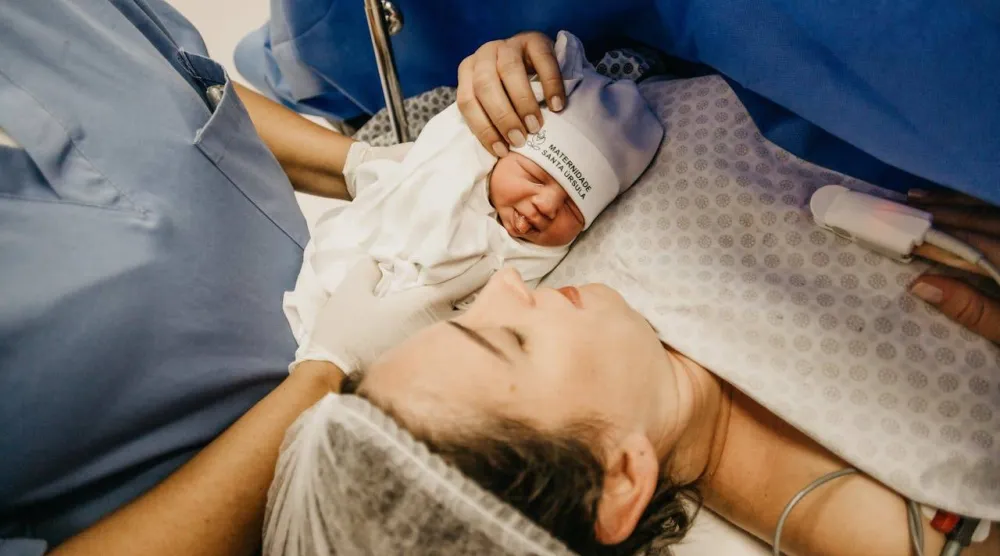 أم في غرفة العمليات تنظر إلى مولودها  (بكسلز)