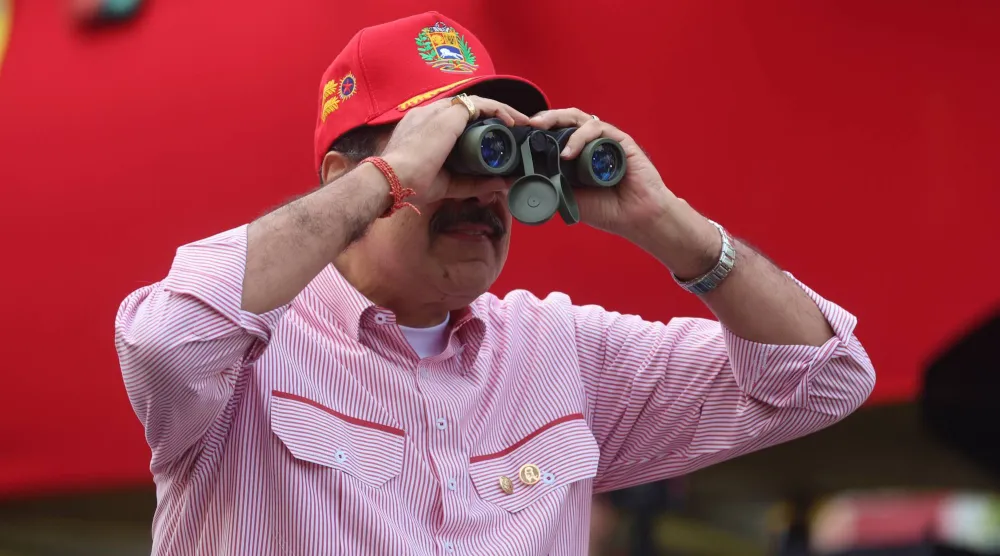 الرئيس الفنزويلي نيكولاس مادورو يتابع بمنظار تجمعاً حاشداً في كاراكاس يوم 1 ديسمبر 2025 (إ.ب.أ)