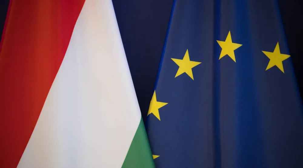 العلم المجري يظهر إلى جانب علم الاتحاد الأوروبي خلال مؤتمر صحافي (د.ب.أ)