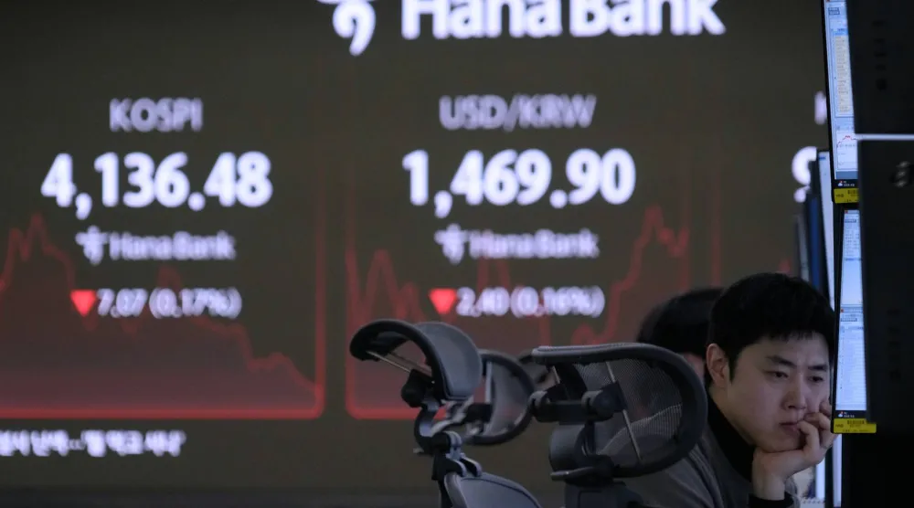 متداول عملات يراقب مؤشر «كوسبي» وسعر صرف الدولار مقابل الوون في «بنك هانا» بسيول (أ.ب)