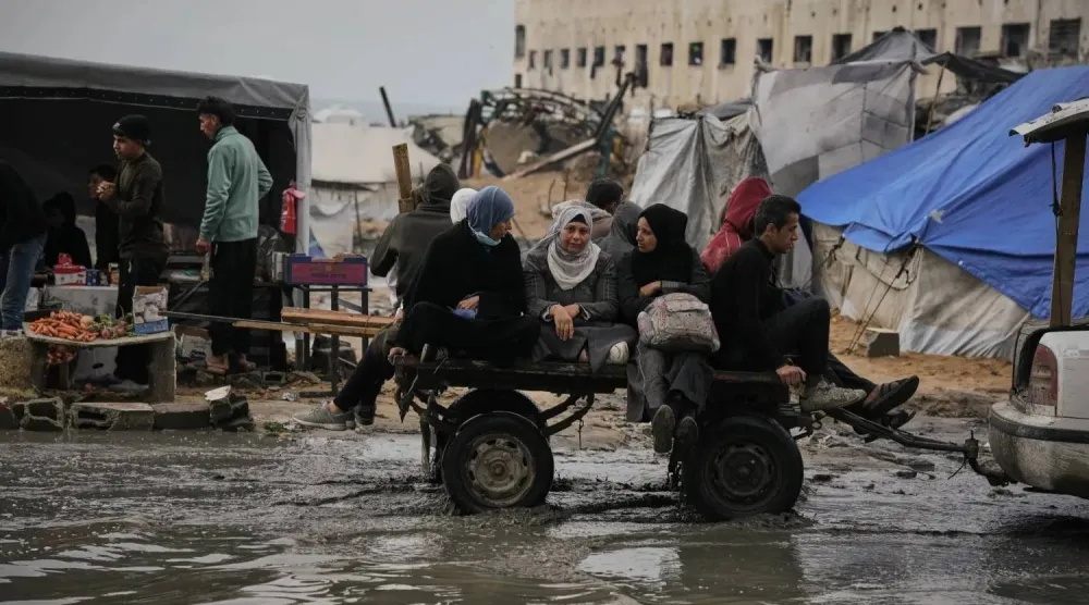 Palestinians ride in a car-drawn cart through a flooded street after a storm in Gaza City on Wednesday (AP)