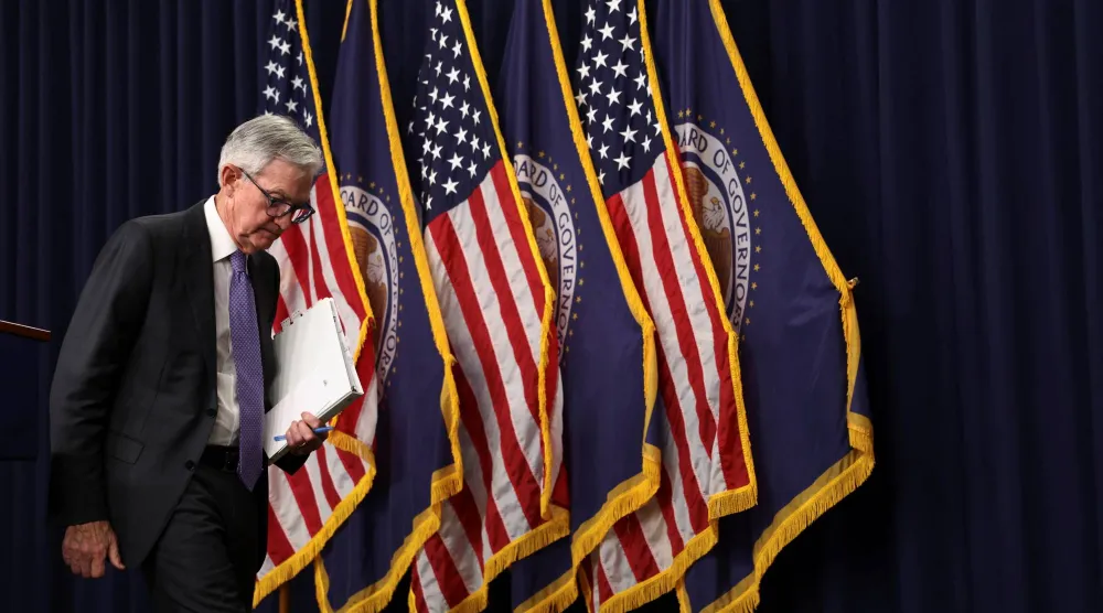 باول مغادراً القاعة بعد انتهاء مؤتمره الصحافي عقب قرار خفض الفائدة (رويترز)