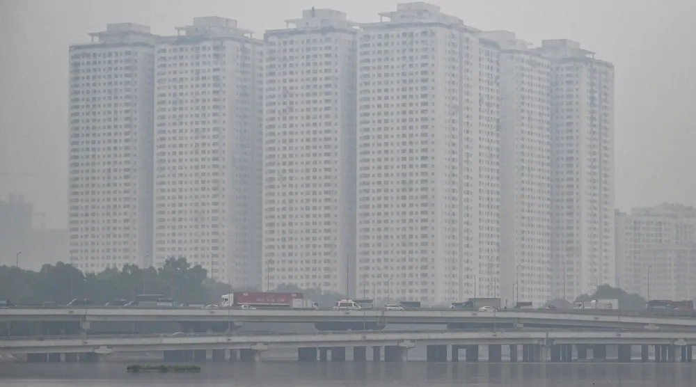 This picture shows vehicles driving on a highway amid heavy air pollution conditions in Hanoi on December 11, 2025. (Photo by NHAC NGUYEN / AFP)