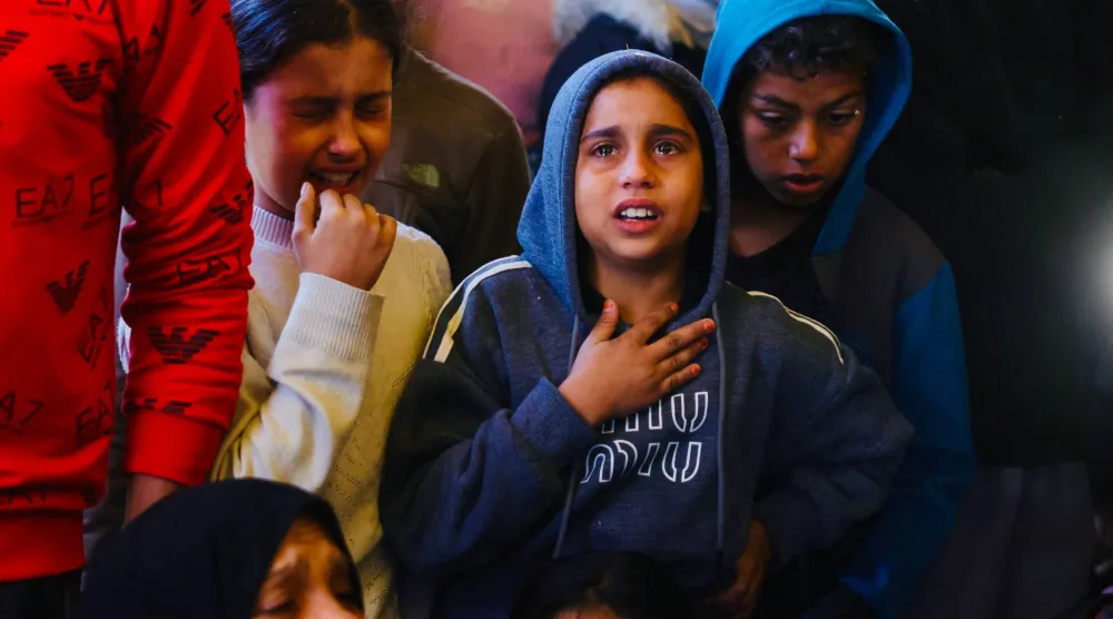 أطفال يبكون أقاربهم الذين قُتلوا علي يد الجيش الإسرائيلي مطلع الأسبوع الحالي في مستشفى ناصر بخان يونس جنوب قطاع غزة (أ.ف.ب)