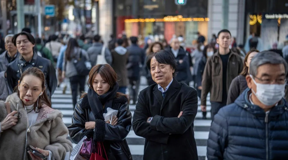 مشاة يعبرون طريقاً في وسط العاصمة اليابانية طوكيو (أ.ف.ب)