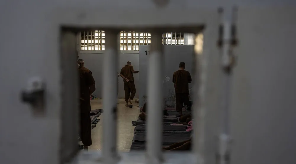 رجال متهمون بالانتماء لتنظيم «داعش» في سجن بشمال شرقي سوريا في مارس الماضي (نيويورك تايمز)