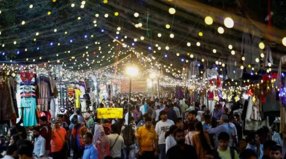 يتسوق الناس في سوق بمدينة نيودلهي (رويترز)