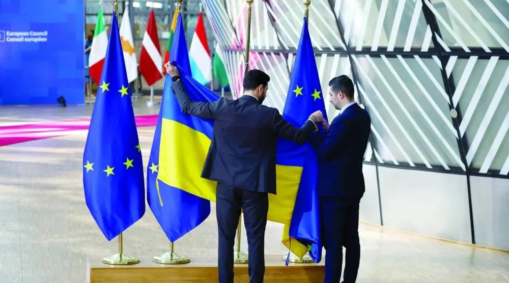 يقوم الموظفون باستبدال عَلم أوكرانيا بعَلم الاتحاد الأوروبي في يوم القمة الخاصة لقادة الاتحاد (أرشيفية - رويترز)