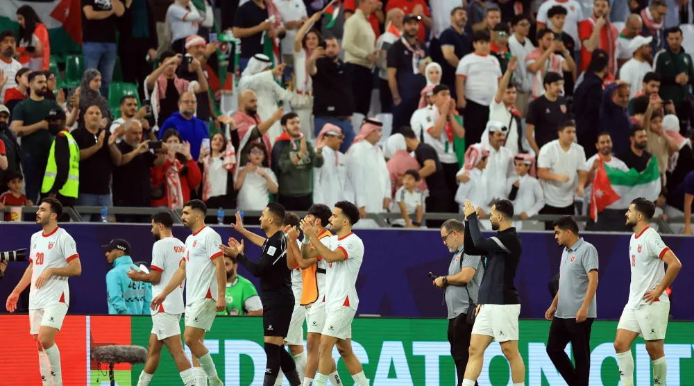 فرحة لاعبي الأردن بالفوز على العراق والتأهل لنصف نهائي كأس العرب (رويترز)