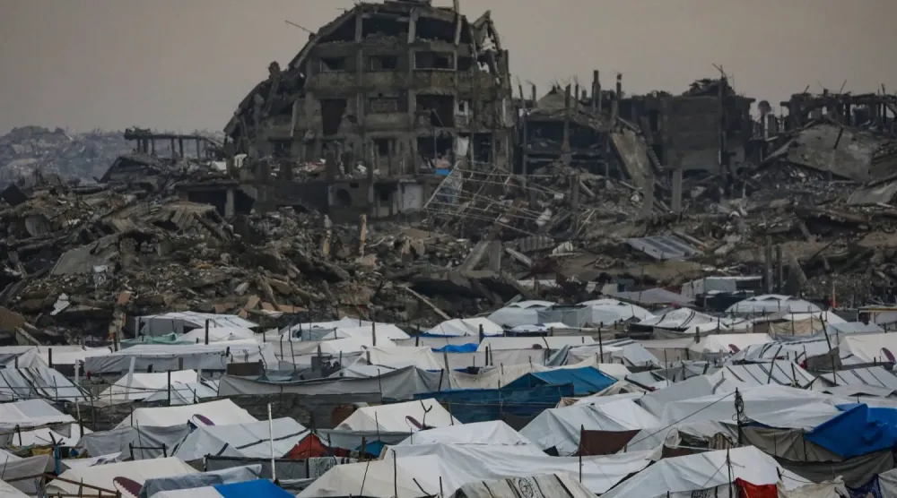 Gazze şehrinin doğusundaki Zeytun mahallesinde, arkalarında yıkılmış binaların görüldüğü Filistinli mülteci çadırları (EPA)