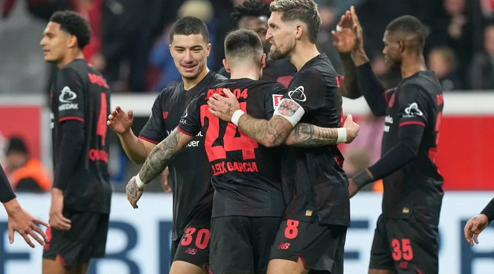 احتفالية لاعبي باير ليفركوزن بالفوز على كولن (أ.ب)