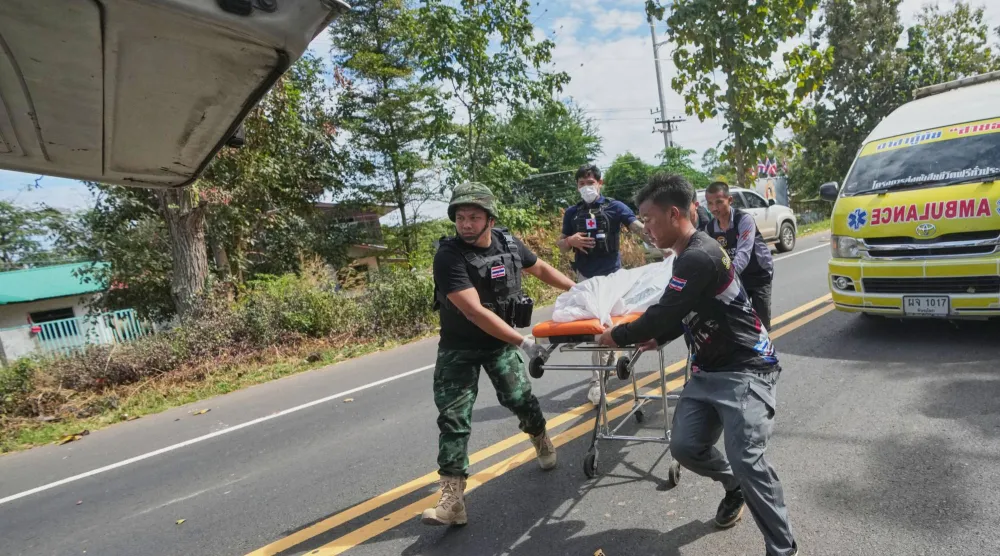 فريق الإنقاذ التايلاندي ينقل جثة إلى سيارة بعد قصف مدفعي كمبودي في مقاطعة سيسكيت اليوم (أ.ب)