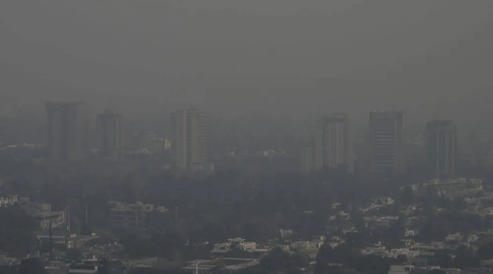 This picture taken on December 9, 2025, shows buildings engulfed in dense smog due to severe air pollution in Islamabad. (Photo by Aamir QURESHI / AFP)