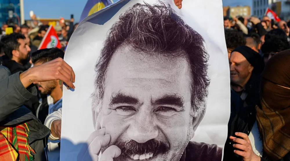 أكراد في جنوب شرقي تركيا يرفعون صورة لزعيم حزب «العمال الكردستاني» مطالبين بإطلاق سراحه بعد دعوته في 27 فبراير الماضي لحل الحزب (أ.ف.ب)