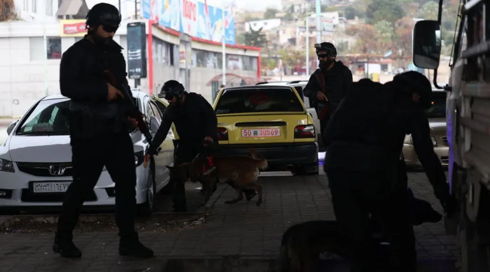 عناصر من وزارة الداخلية تستخدم الكلاب المدربة لفحص السيارات في إحدى النقاط الأمنية (الداخلية السورية) 