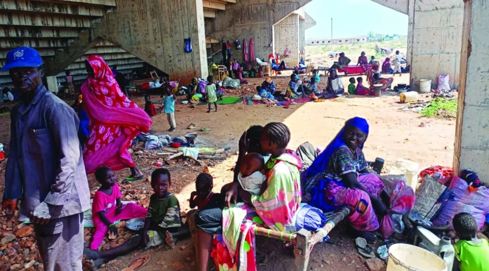 عائلات سودانية نازحة من كردفان في ملعب كرة قدم ببلدة كادوقلي جنوب الإقليم (أ.ب)