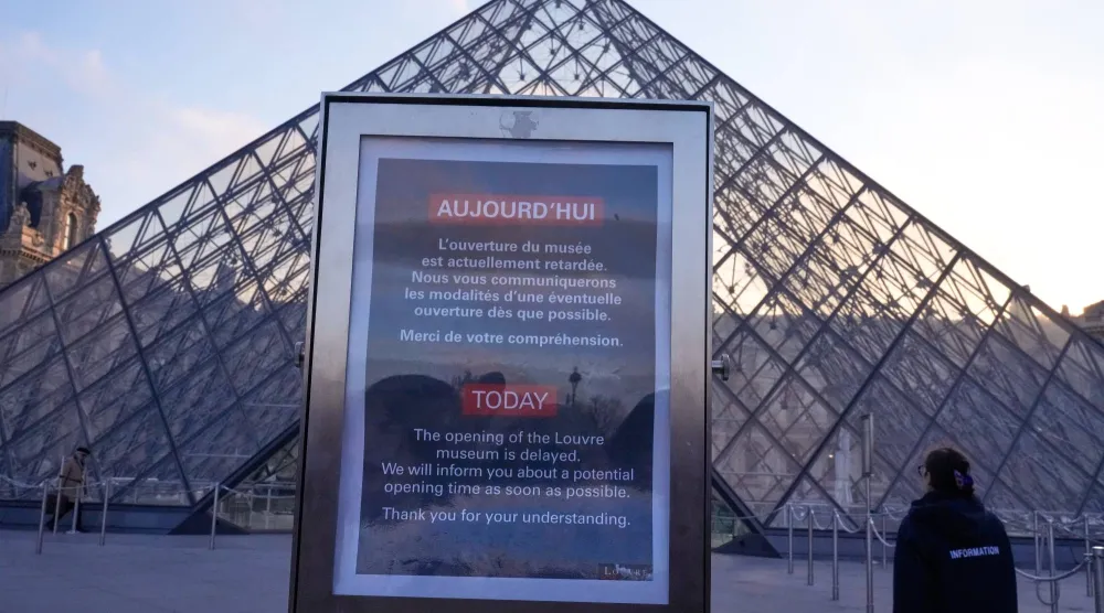 لوحة إعلانية تُشير إلى تأجيل فتح أبواب متحف اللوفر الأكثر زيارة في العالم (أ.ب)