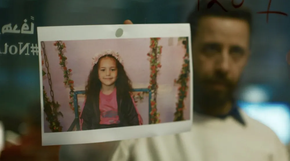الممثل معتز ملحيس وأمامه صورة الطفلة هند رجب في مشهد من الفيلم (أ.م.د.ب)