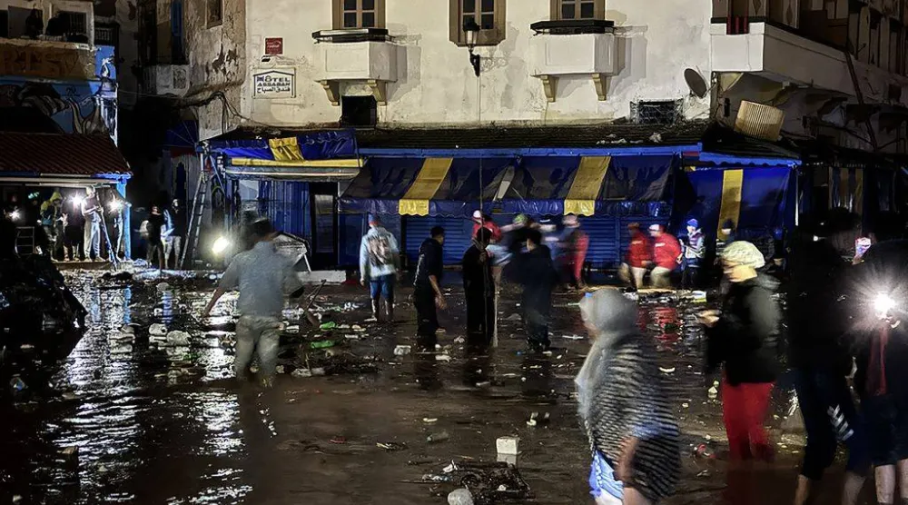 رجال الإنقاذ والسكان المحليون في أحد شوارع مدينة آسفي الغارقة بالمغرب (أ.ف.ب)