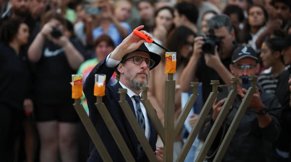 أضاء الحاخام ليفي وولف الشمعدان اليهودي (المينوراه) في جناح بوندي تكريماً لضحايا حادث إطلاق النار الذي وقع خلال احتفال بعيد يهودي على شاطئ بوندي في سيدني بأستراليا يوم 15 ديسمبر 2025 (رويترز)