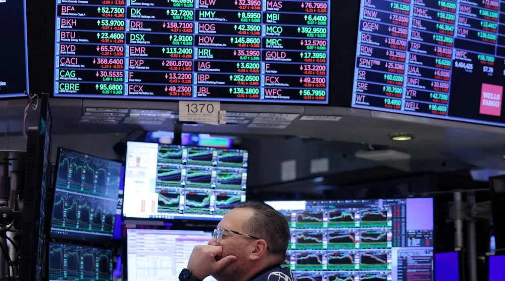 يعمل أحد المتداولين في قاعة التداول ببورصة نيويورك (رويترز)