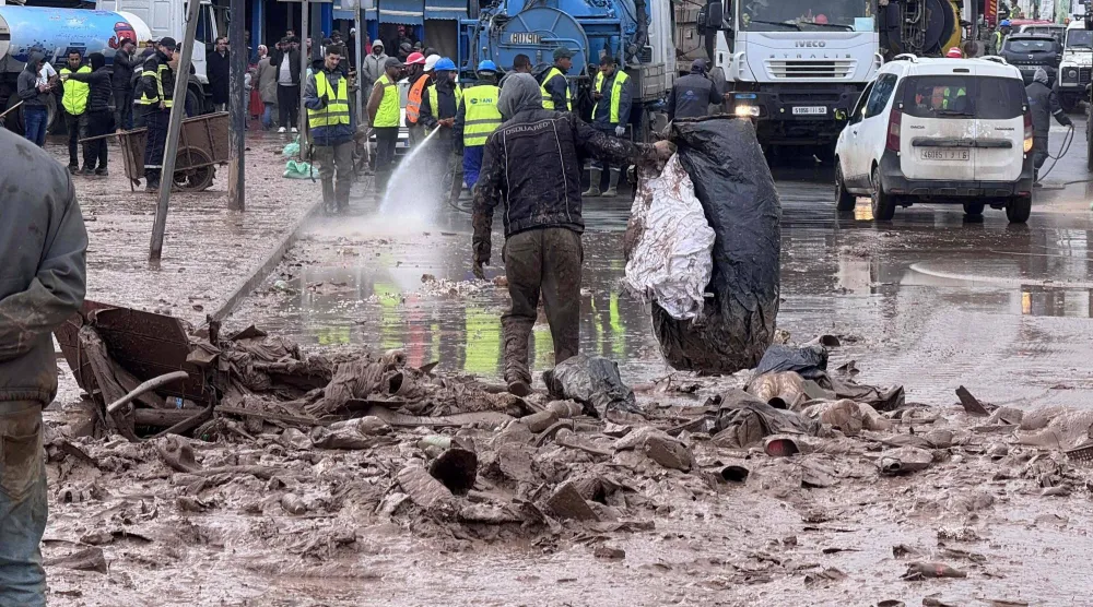 عمال البلدية يرفعون الركام من أحد شوارع بلدة آسفي الساحلية الاثنين (أ.ف.ب)