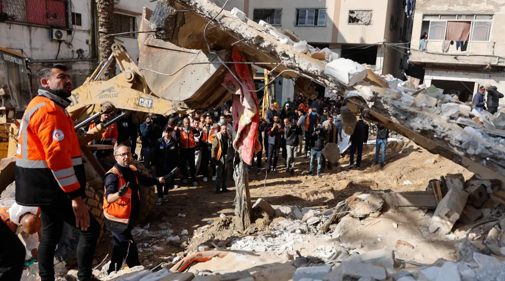 أفراد من الدفاع المدني الفلسطيني يبحثون عن جثامين عائلة سالم في أنقاض مبنى دُمر عام 2023 في حي الرمال بمدينة غزة 15 ديسمبر 2025 (أ.ف.ب)