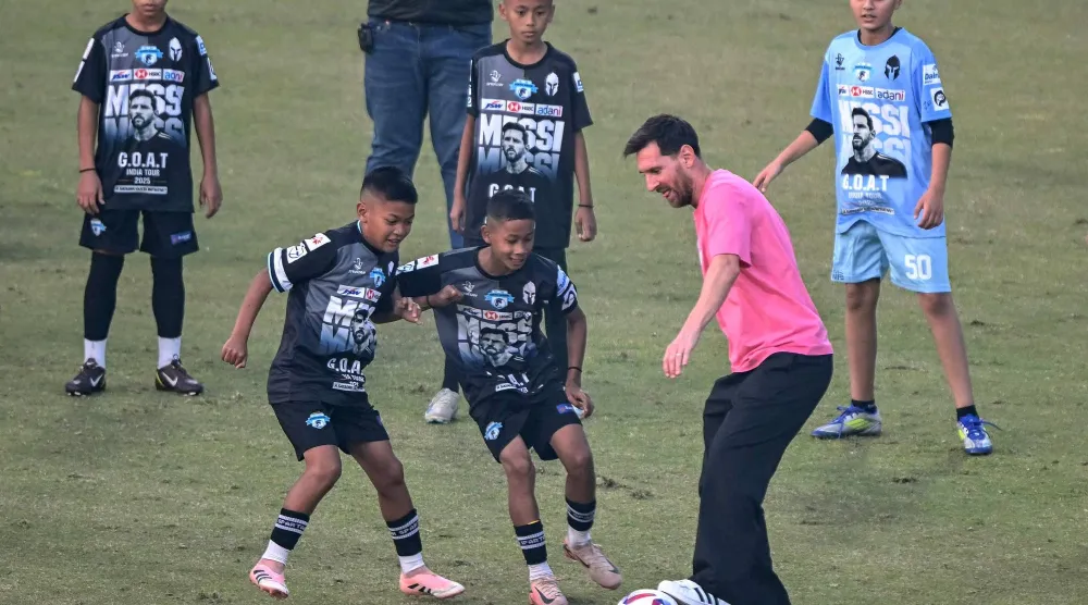 ليونيل ميسي يلعب الكرة مع أطفال في نيودلهي (أ.ف.ب)