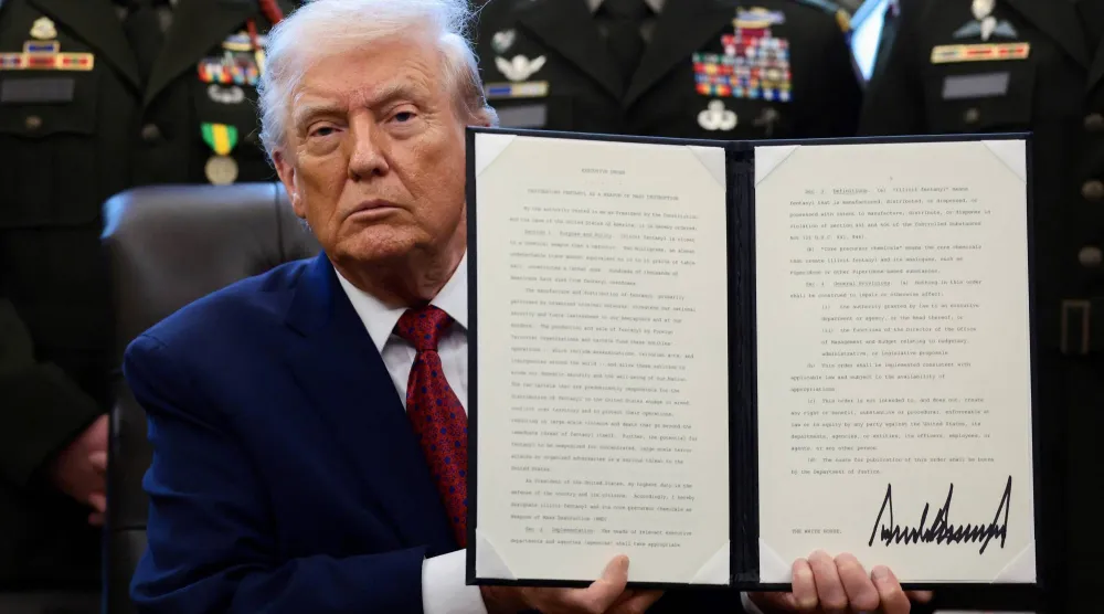 الرئيس الأميركي خلال توقيعه الأمر التنفيذي في البيت الابيض (رويترز)