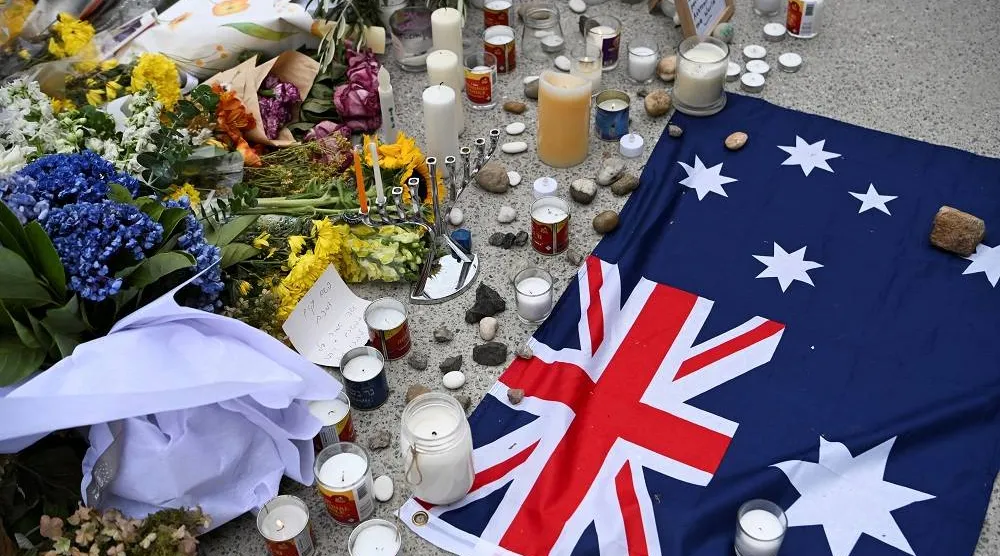 An Australian flag is placed near flowers laid as a tribute at Bondi Beach to honor the victims of a mass shooting that targeted a Hanukkah celebration at Bondi Beach on Sunday, in Sydney, Australia, December 16, 2025. (Reuters)