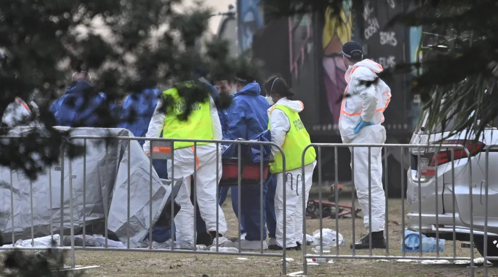 خبراء الأدلة الجنائية يقومون بمعاينة جثة أحد الضحايا في موقع إطلاق النار على شاطئ بونداي في سيدني (إ.ب.أ)