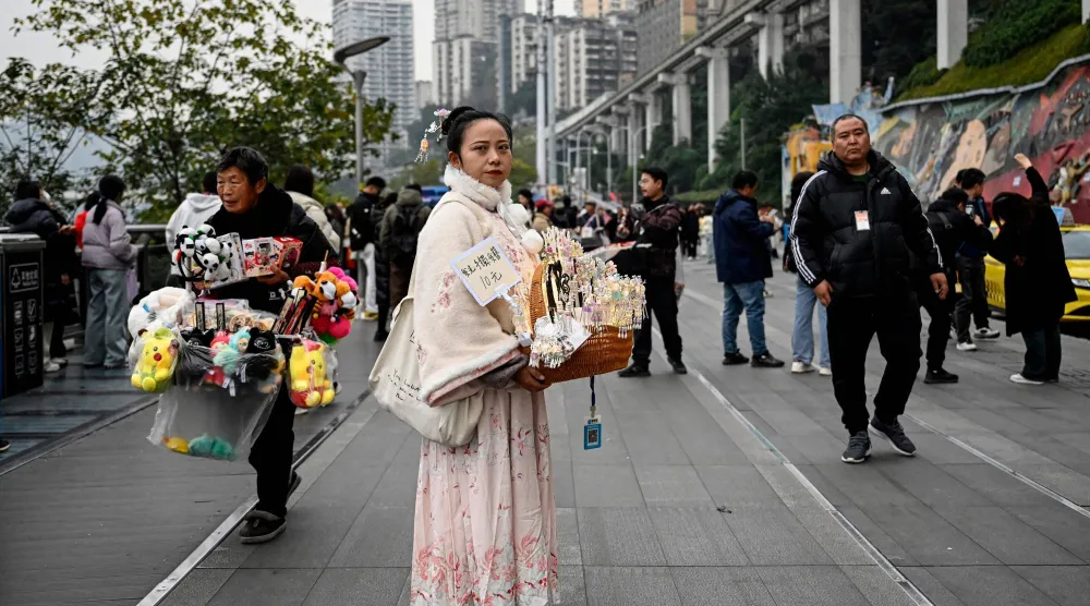 بائعون في شارع تجاري بإحدى مدن جنوب شرقي الصين (أ.ف.ب)