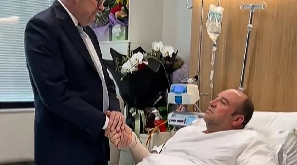 تُظهر هذه اللقطة من فيديو نُشر على حساب رئيس الوزراء الأسترالي أنتوني ألبانيز (@AlboMP) على تويتر (المعروف سابقاً باسم X) في 16 ديسمبر/كانون الأول 2025، ألبانيز (يسار) وهو يلتقي بأحمد الأحمد الرجل الذي نزع سلاح أحد المهاجمين خلال هجوم شاطئ بوندي في مستشفى بسيدني (أ.ف.ب)