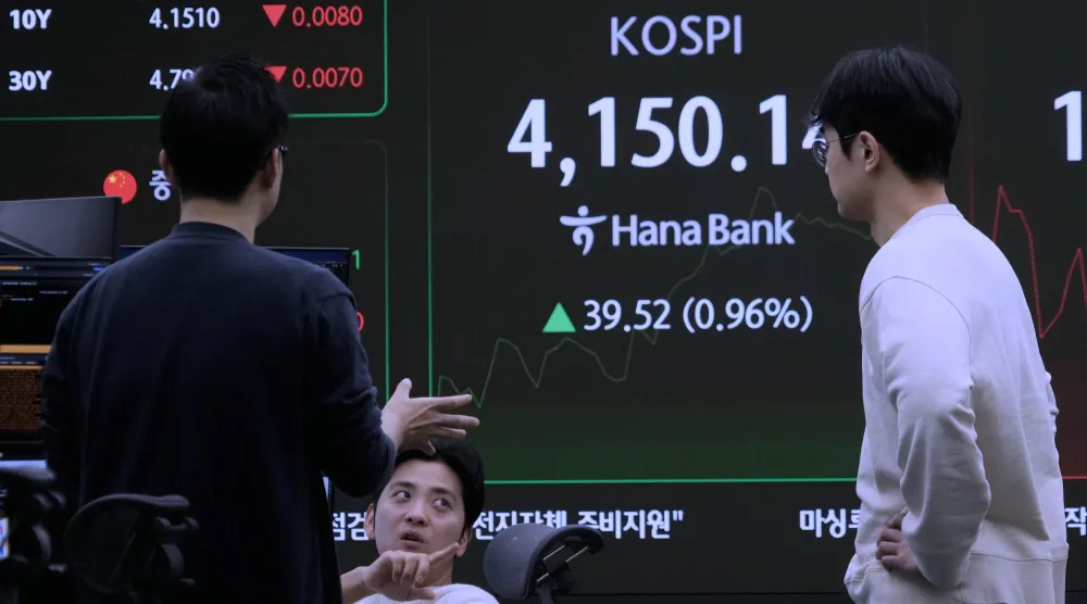 متعاملون بالعملات يتابعون مؤشر «كوسبي» في غرفة تداول بنك «هانا» بسيول (أ.ب)