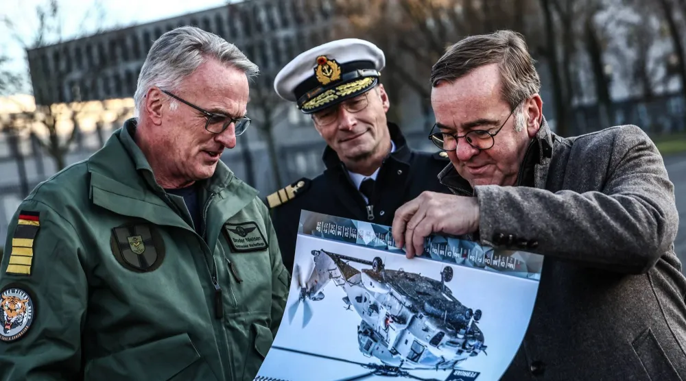 وزير الدفاع الألماني بوريس بيستوريوس (يمين) ورئيس البحرية الألمانية نائب الأدميرال يان كريستيان كاك (وسط) والكابتن برودر نيلسن ينظرون إلى أوراق عسكرية خلال حفل تسليم مروحية «سي تايجر» بوزارة الدفاع في برلين... 16 ديسمبر 2025 (إ.ب.أ)