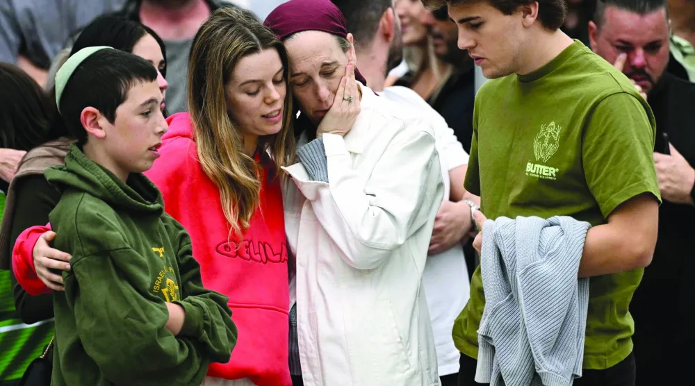 صورة من أعلى - أفراد عائلات الضحايا يتفاعلون وهم يقفون مع المعزين قرب النصب التذكاري في جناح بوندي إحياءً لذكرى ضحايا حادث إطلاق النار على شاطئ بوندي في سيدني بتاريخ 16 ديسمبر 2025... وقد وافق قادة أستراليا على تشديد قوانين حيازة الأسلحة بعد أن قتل مهاجمون 15 شخصاً في مهرجان يهودي (أ.ف.ب)