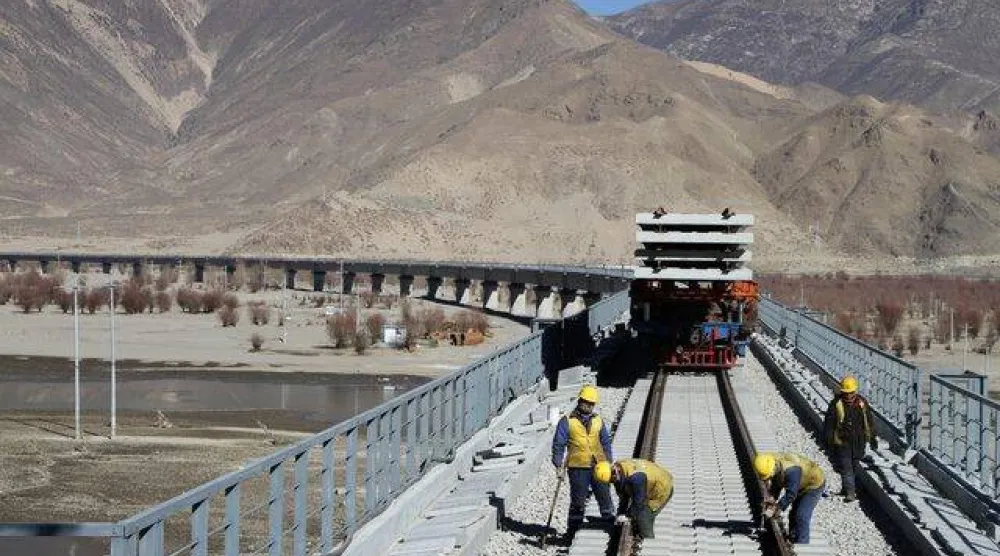 عمال صينيون على جسر فوق نهر يارلونغ تسانغبو أثناء عملهم في مشروع سابق (رويترز)