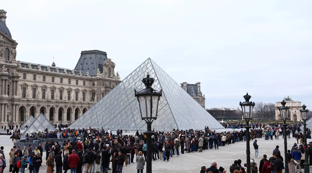 أشخاص يصطفّون لدخول متحف اللوفر (رويترز)