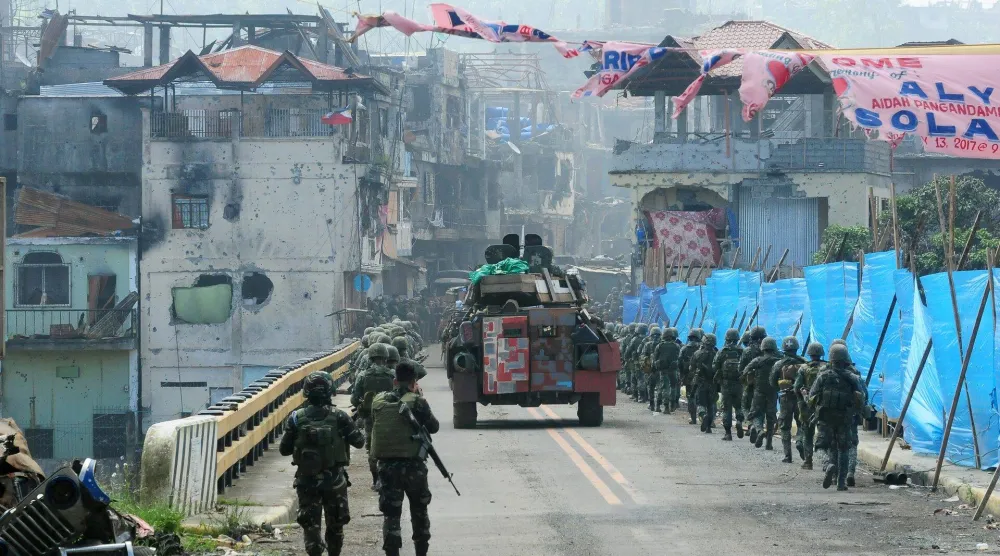 ناقلة جنود مدرعة وقوات حكومية تسير باتجاه جسر ماباندي في مدينة ماراوي بجزيرة مينداناو الفلبينية في 30 أغسطس 2017 (رويترز)