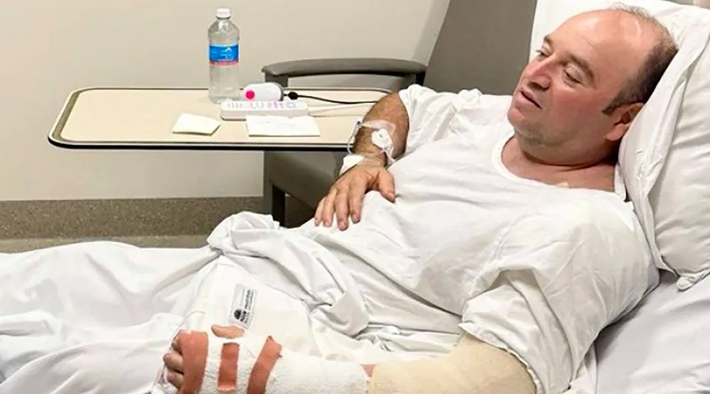 أحمد الأحمد الرجل الذي تصدّى لأحد مهاجمي شاطئ بونداي ونزع سلاحه وهو يتحدث إلى رئيس وزراء ولاية نيو ساوث ويلز كريس مينز (أ.ف.ب)