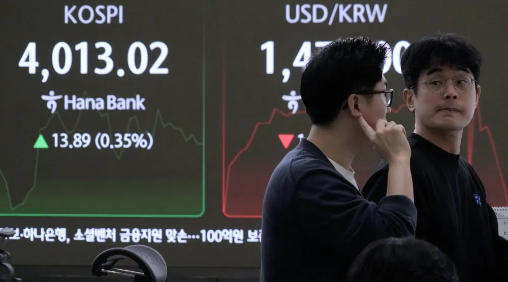 متعاملو العملات يراقبون مؤشر «كوسبي» في غرفة تداول بنك هانا بسيول (أ.ب)