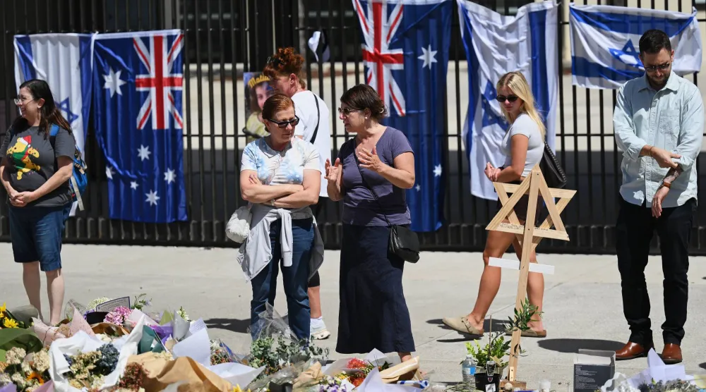 يقف الناس بالقرب من إكليل من الزهور خارج جناح بونداي في شاطئ بونداي في سيدني الخميس 18 ديسمبر 2025 (أ.ب)