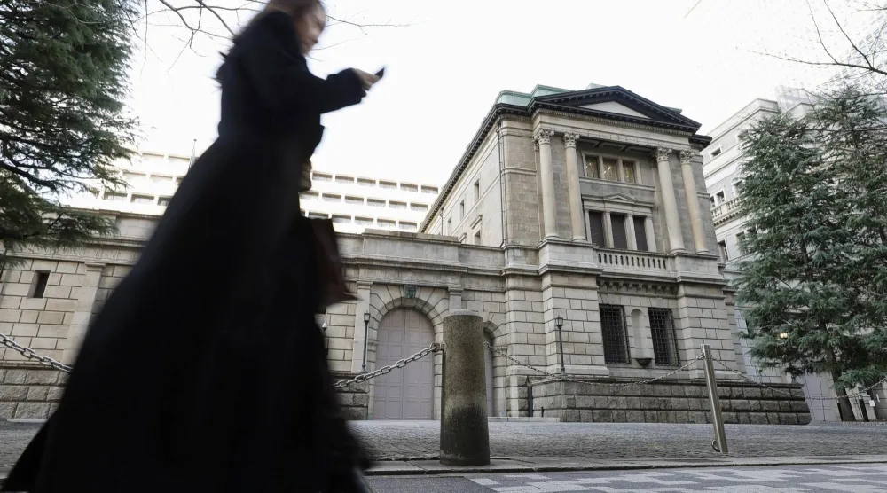 سيدة تمر أمام مقر بنك اليابان المركزي في وسط العاصمة طوكيو (أ.ب)