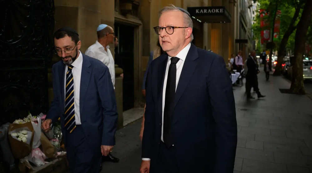 الحاخام بنيامين إلتون (يسار) يستقبل رئيس الوزراء الأسترالي أنتوني ألبانيز (يمين) لدى وصوله إلى الكنيس الكبير في سيدني بأستراليا 19 ديسمبر(رويترز)