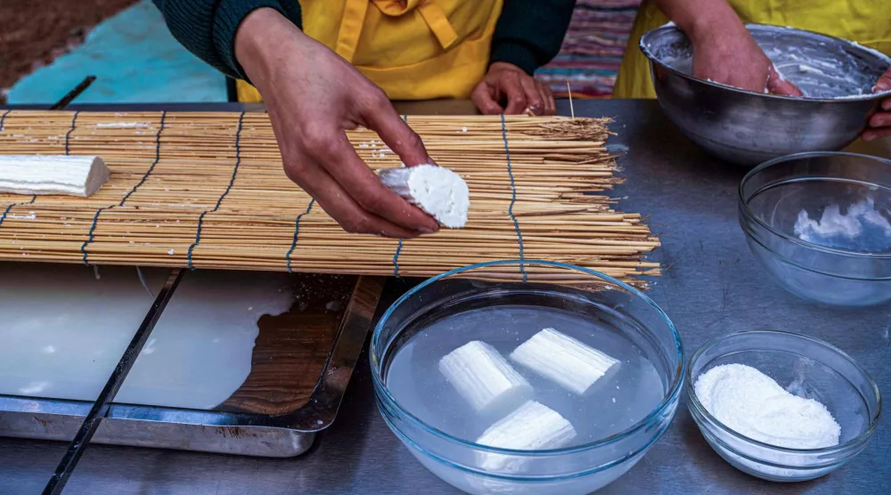 سيدة مصرية تضع قطعاً من جبن القريش المصنع حديثاً (أ.ف.ب)