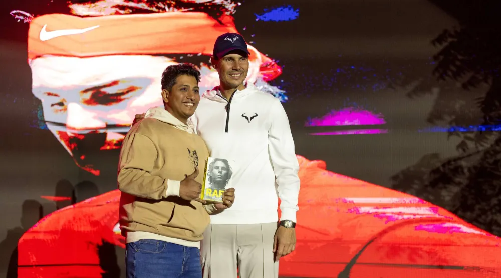 أحد معجبي النجم الإسباني يحمل كتاباً يروي مسيرته (الشرق الأوسط)