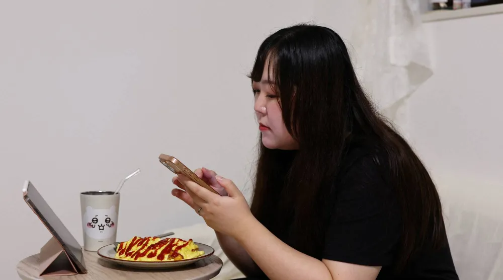 يورينا نوغوتشي البالغة من العمر 32 عاماً تتحدث مع كلاوس شريكها في الذكاء الاصطناعي عبر تطبيق «شات جي بي تي» خلال تناول العشاء في منزلها بطوكيو (رويترز)