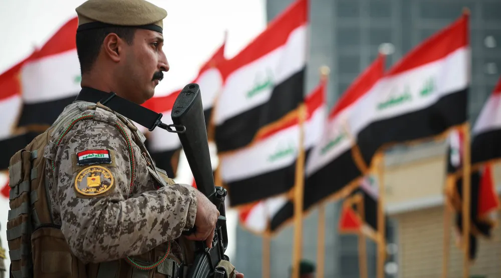 ضابط من القوات المسلحة العراقية يقف حارساً خلال عرض عسكري بمناسبة الذكرى الثامنة لانتصار العراق على تنظيم «داعش» (د.ب.أ)