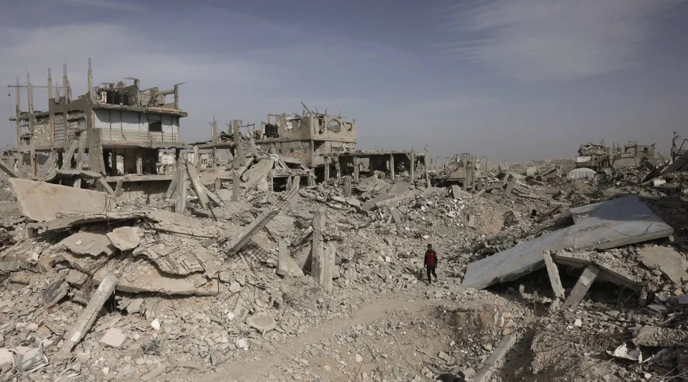 فلسطيني يمشي وسط أنقاض المباني المدمرة جنوب قطاع غزة (أ.ف.ب)